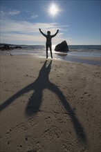 Silhouette of senior woman jumping on beach