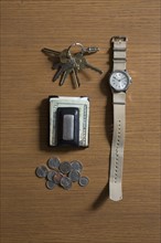Watch, keys and money on table