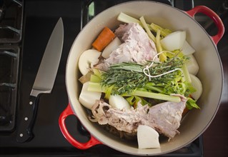 Turkey leftovers and vegetables in pot on stove