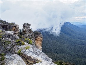 Australia, New South Wales, Katoomba, Large rocks and mountains in clouds