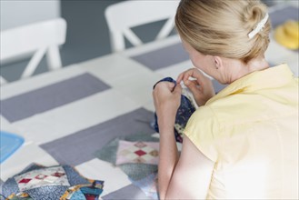 Woman making quilt