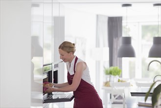 Mature woman preparing food in modern kitchen