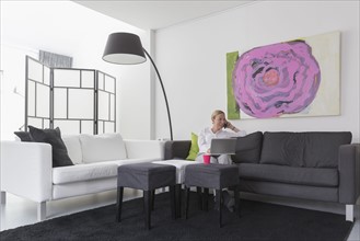 Mature woman sitting in modern living room