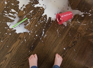Boy's feet by spilt milkshake