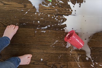 Boy's feet by spilt milkshake