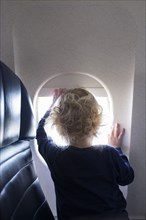 Boy by window on airplane