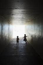 Silhouettes of children in tunnel