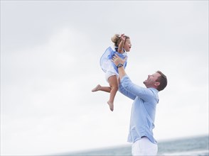 Father lifting daughter