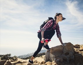 Woman hiking over rocks