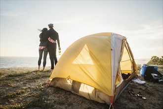 Couple by tent at beach