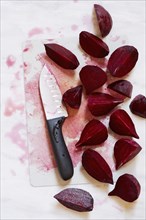 Beetroot on chopping board with kitchen knife