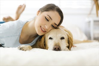 Woman lying on bed with dog