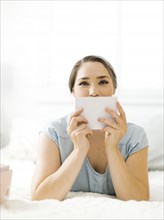 Woman holding envelope on bed