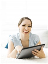 Smiling woman holding folder on bed