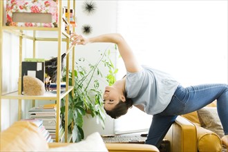 Woman bending over backwards while dusting
