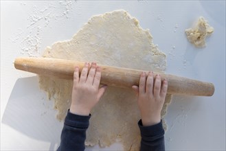 Boy's hands rolling dough