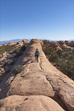 Woman hiking on rock in Arches National Park, Utah, USA