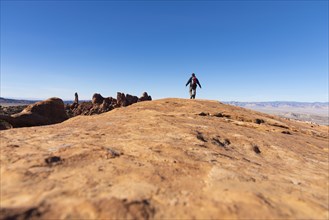 Man hiking on rock in Arches National Park, Utah, USA