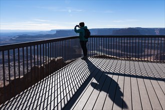 Woman taking photograph on observation point in Dead Horse Point State Park in Utah, USA