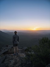 Woman standing on peak of Blue Mountains at sunrise in New South Wales, Australia