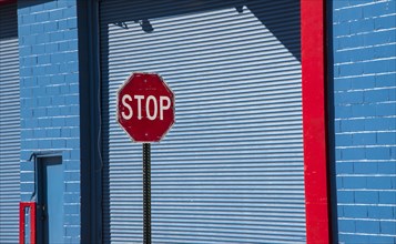 Stop sign by blue garage door