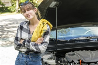 Woman with oil rag beside car