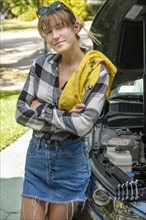 Woman with oil rag beside car