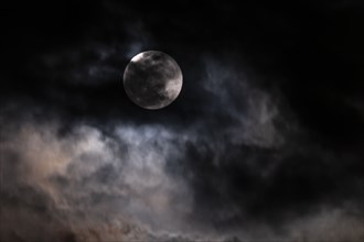 Full moon among clouds