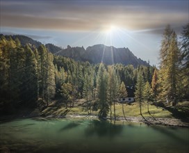 Lake and pine forest at sunrise in the Dolomites, South Tyrol, Italy