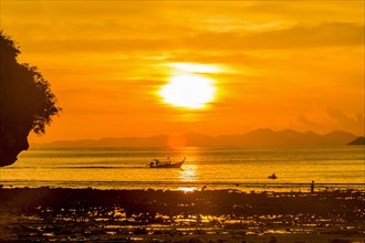 Silhouette of boat at sunset in West Railay, Thailand