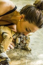 Woman kissing tiger cub