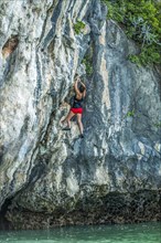 Woman rock climbing in Phuket, Thailand