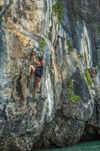 Woman rock climbing in Phuket, Thailand
