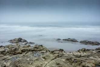 Long exposure shot of rocks on beach in Morro Bay, California, USA