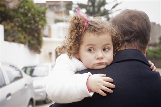 Girl being carried by her father