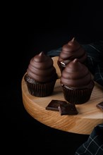 Chocolate cupcakes on wooden cutting board