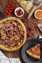 Pizza and ingredients on wooden table