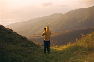 Man in yellow jacket taking photographs in the Carpathian Mountain Range