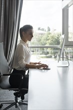 Young businesswoman working on desktop computer