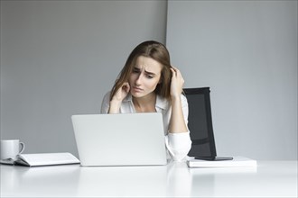 Frustrated businesswoman working at laptop