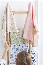 Woman choosing fabric from rack