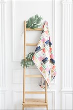 Fabric on rack with palm leaves