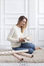 Woman sitting on rug with variety of fabrics