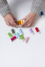 Woman's hands organizing colorful spools of thread