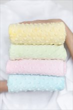 Hands of woman holding pastel color fabrics