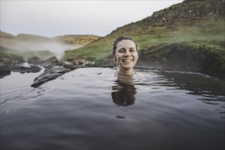 Woman bathing in hotpool in Iceland
