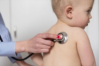 Paediatrician using stethoscope on girl