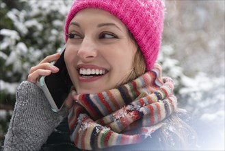 Young woman on phone call in snow