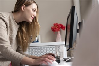 Young woman using desktop PC
