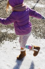 Girl wearing purple coat walking on snow